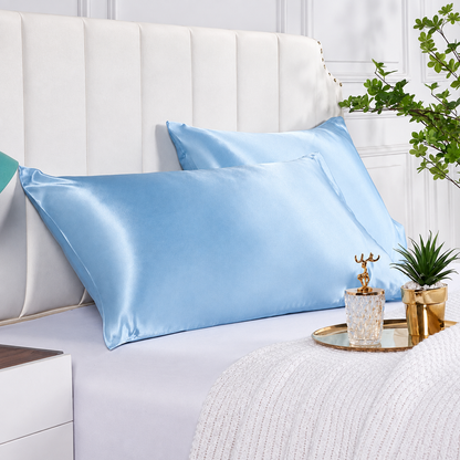 Light blue satin pillowcases styled on a bright modern bed